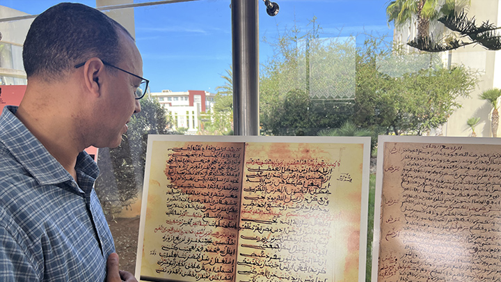 man looks at old manuscript